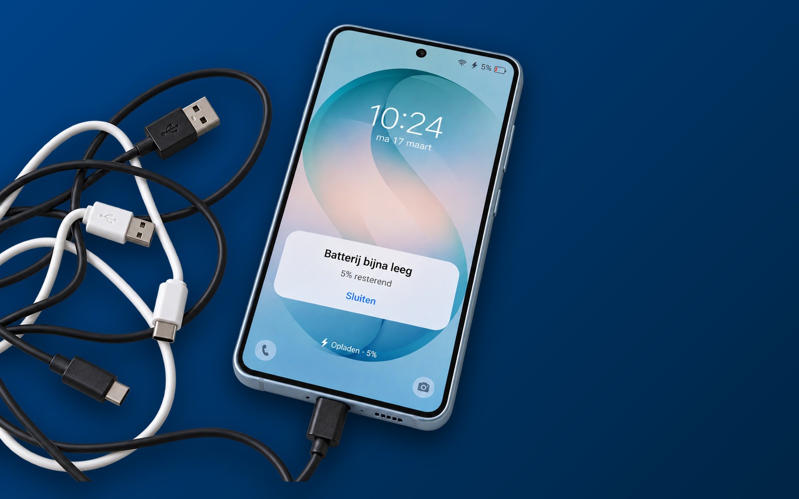 Samsung met de melding Batterij bijna leeg naast een wirwar van oplaadkabels